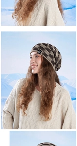 Detail of winter knit beanie showing brown checkered pattern and warm texture on snow