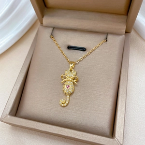 Elegant gold cat pendant necklace with pink and clear crystals in a beige jewelry box