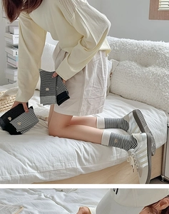 Detail von schwarz-weiß gestreiften Baumwollsocken mit kleinem gesticktem Bärenmuster