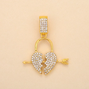 Close-up of a gold-plated heart pendant pierced by an arrow with crystal rhinestones