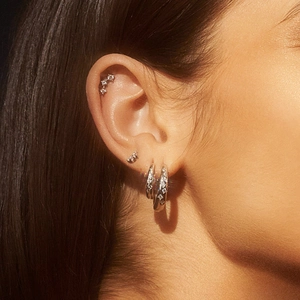 Macro shot of S925 sterling silver star earrings with zircons on a woman ear