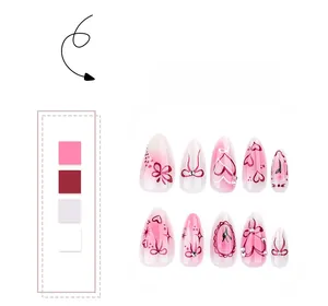 Detail of pink gradient press-on nails with bow, heart patterns and pearl accents