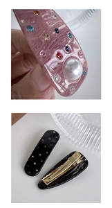 Detailed macro view of pink acetate hair clip with pearls and golden metal spring clip