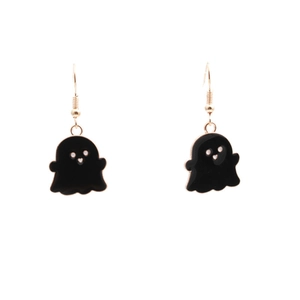 Close-up of Halloween ghost earrings featuring black enamel finish and gold hooks