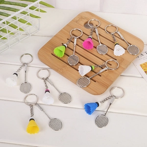 Colorful badminton racket and shuttlecock keychains on a white wooden tabletop