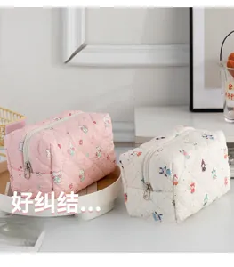 Close-up of quilted cotton makeup bags in pink and cream with cute animal patterns