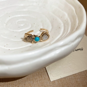 Macro shot of vintage resin open ring with turquoise bead and engraved fish detail