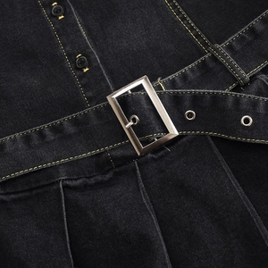 Detail der schwarzen Denim-Taille mit gelben Kontrastnähten und silberner Metallschnalle