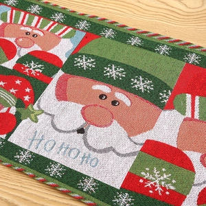 Macro view of Christmas table runner with knitted Santa motifs and Ho Ho Ho text on wood