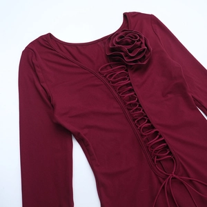 Détail de la robe bordeaux avec rose 3D appliquée et design évidé à lacets croisés
