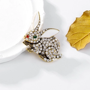 Sparkling rabbit brooch with crystals and enamel finish on elegant white ceramic display