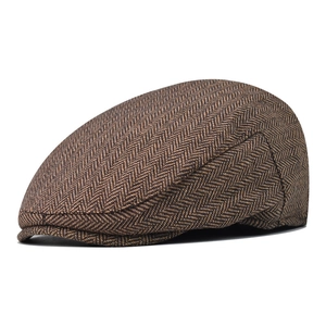 Close-up of brown herringbone flat cap showing wool blend fabric texture and pattern