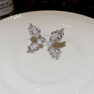 Detailed shot of silver butterfly wing ear cuff with sparkling zircon on ceramic
