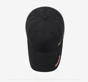 Détail du tissu en maille laser respirant et de la broderie dorée sur la casquette noire