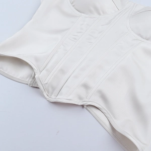 Détail du corset en satin blanc montrant les baleines verticales et les finitions de couture