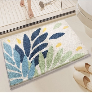 Close-up of soft floral bath mat featuring green and blue botanical leaf patterns