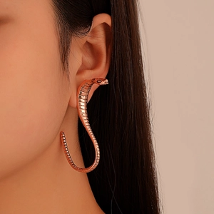 Exaggerated vintage snake-shaped earrings in rose gold with realistic scale texture on model