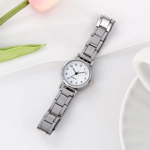 Detailed close-up of white quartz watch dial with silver metal strap and numeric indices