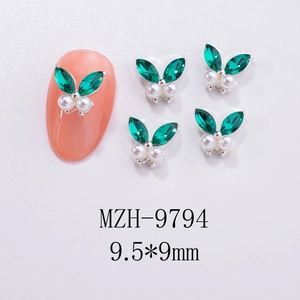Macro shot of 9.5x9mm green gemstone and pearl butterfly nail art studs with silver base