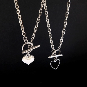Macro view of silver OT toggle clasp heart necklaces on a professional black background