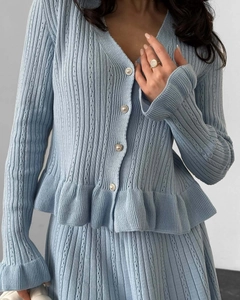 Vue détaillée de l'ensemble en maille bleu clair avec boutons en perles et volants
