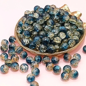 Macro shot of 10mm blue crackle glass beads in a gold tray for DIY jewelry making