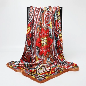 Detailed view of large square satin scarf featuring vibrant paisley prints and silk texture