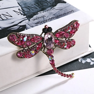 Detailed view of dragonfly brooch with pink and purple rhinestones on bronze base