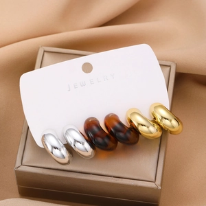 Three-pair set of chunky vintage C-shape hoop earrings in gold, silver, and amber leopard