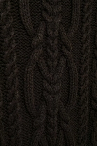 Detailed macro shot of dark brown cable knit texture on a high neck sweater vest
