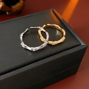 Bagues ouvertes style bambou or et argent avec zircons sur boîte à bijoux noire