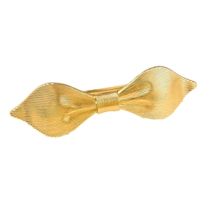 Elegant gold metal bow hair clip with textured brushed finish on white background