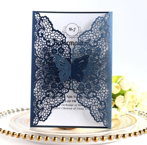 Navy blue laser cut wedding invitation with elegant bow and white floral detail