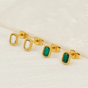 Détail macro de boucles d'oreilles carrées en zircon et acier inoxydable doré