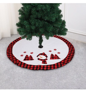 Close-up of white Christmas tree skirt featuring snowman patterns and red plaid border
