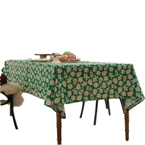 Green Christmas tablecloth with gingerbread men and snowflakes on a rectangular table