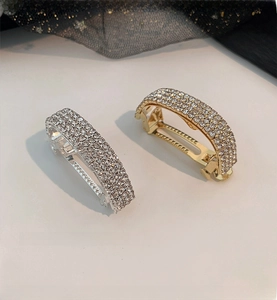 Detail view of sparkling four-row rhinestone ponytail clips in gold and silver finish