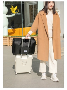 Detail of black travel bag with trolley sleeve attached to a white suitcase handle