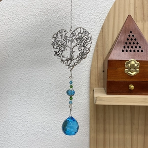 Detail of silver heart suncatcher with tree of life and blue faceted crystal pendant
