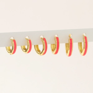 Detailed close-up of 18K gold-plated hoops with pink enamel coating on white display stand