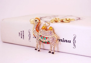 Close-up of a golden camel keychain with sparkling rhinestones and colorful enamel details