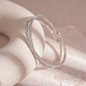 Vue rapprochée du bracelet double rang en argent avec zircons sur une surface texturée