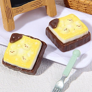 Macro detail of miniature chocolate resin bread charms with cute bear faces for DIY crafts