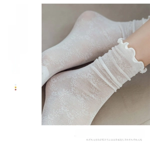 Detail von weißen Netzsocken aus Spitze mit atmungsaktivem Baumwollgewebe und Rüschen