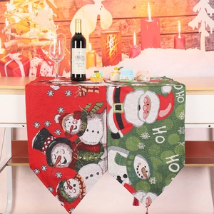 Christmas table runner with red and green plaid patterns and festive tassels
