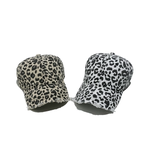 Close-up of distressed leopard print baseball caps with vintage frayed edge details