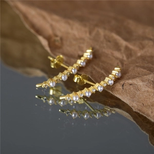 S925 silver gold pearl earrings with rows of diamonds on a vintage brown background