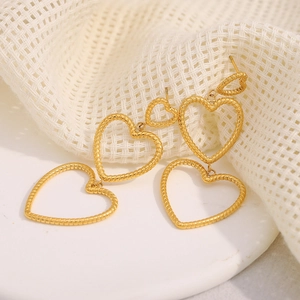 Macro shot of 18K gold plated heart earrings with snake skin texture on white mesh