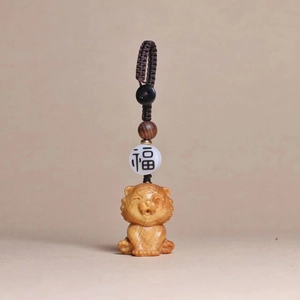 Detailed macro view of hand-carved wood tiger pendant with traditional Fu bead and rope