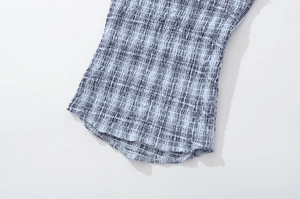 Detailed close-up of blue and white checkered fabric with smocked elastic texture